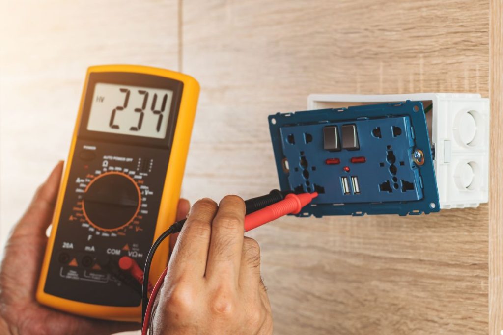 Electrical technician measuring circuit voltage with a multimeter, focused on ensuring accurate readings for safety.