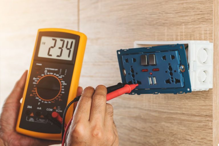 Electrical technician measuring circuit voltage with a multimeter, focused on ensuring accurate readings for safety.