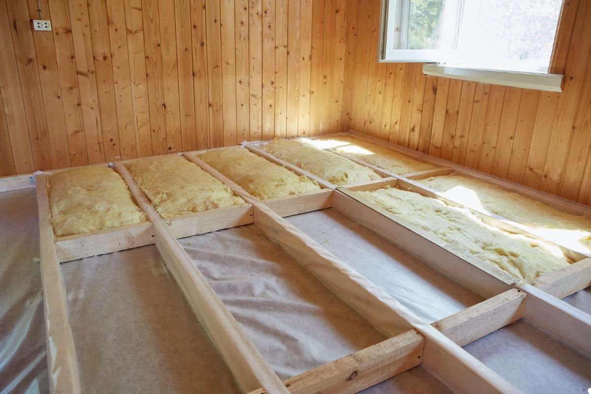 A room featuring wooden walls with visible insulation, creating a warm and rustic atmosphere.